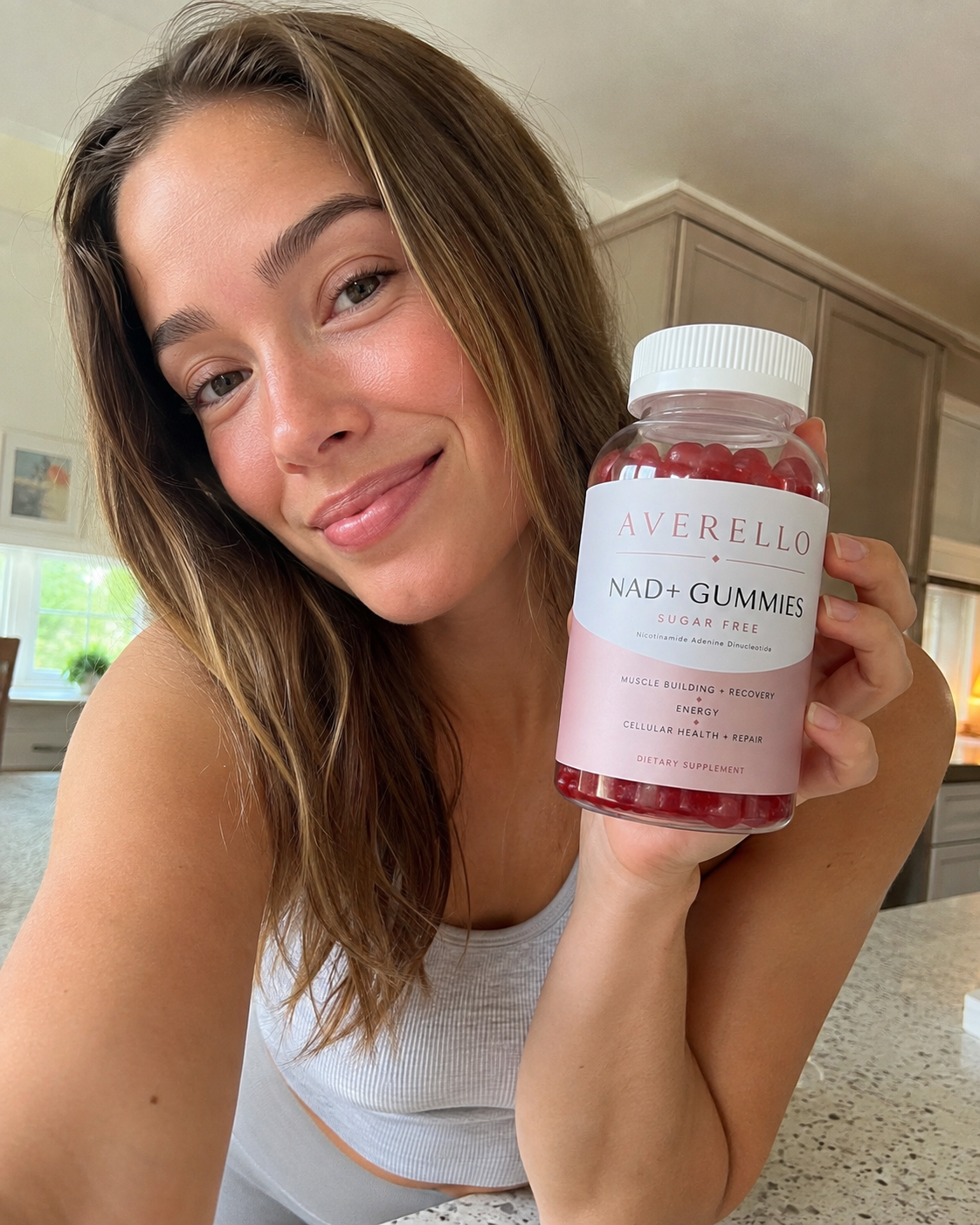 Hannah L. holding a bottle of Averello NAD+ Gummies